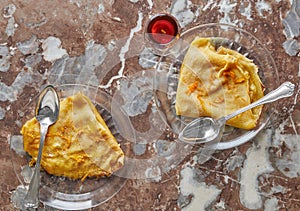 Pancakes with Crepe Suzette, in transparent plate with glass of liqueur. French cuisine, step by step recipe