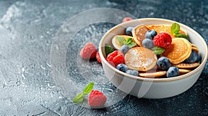 Pancakes with fresh berries and powdered sugar on dark background