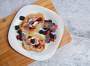 Pancakes with fresh blackberries and raspeberries, top view, horizontal