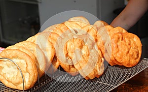 pancakes fried in boiling oil for sale in the street food stall during the village festival