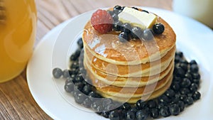 Pancakes with honey, strawberries and blueberries