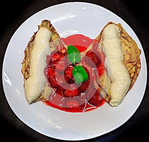 Pancakes with ice cream drizzled with strawberry