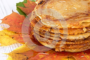 Pancakes with maple syrup on autumn multicolored leaves