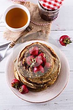 Pancakes over white wooden background