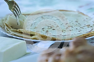 Pancakes in a plate and fork with butter