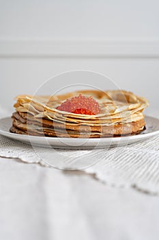 Pancakes on a plate with red caviar