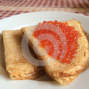 Pancakes with red salmon Caviar on plate for dating valentines day concept, traditional Russian cuisine