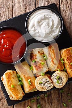 Pancakes rolls with chicken, cheese and mushrooms close-up and s