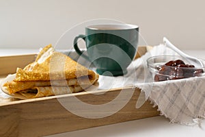 Pancakes Russian Blini with strawberry jam and tea on a tray. Breakfast. Ð¡lose up