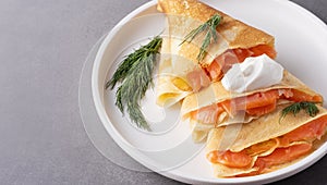 Pancakes with salmon, sour cream and greenstuff. Thin, not sweet blinchiki stuffed with red fish. Feast of Maslenitsa photo