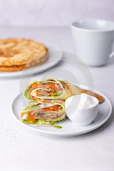 Pancakes with salmon trout, sour cream and greenstuff. Thin, not sweet blinchiki stuffed with fish. Traditional Russian dish.