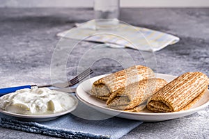 Pancakes with sour cream on a plate. Russian cuisine. Maslenitsa