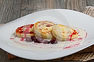 Pancakes with sower cream and cherry cyrup photo
