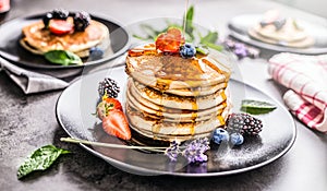 Pancakes with strawberries blackberries blueberries and lavender