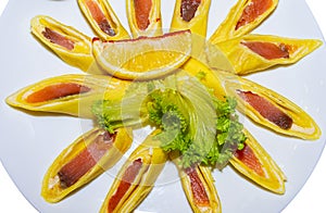 Pancakes stuffed with red fish and cut into pieces. Isolated plate with pancakes close-up