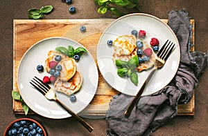 Pancakes with summer berries served for breakfast, overhead view on a table setting