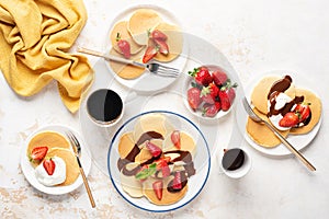 Pancakes with whipped cream, strawberries and chocolate sauce