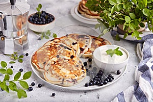 Pancakes with wild blueberries, served with sour cream and fresh berries