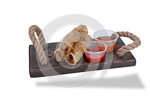 pancakes on a wooden stand with jars of hot sauce. Nem, Vietnamese rice paper rolls