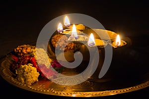 panch pradeep or five headed oil lamp burning with glowing flame with marigold flowers. these are used in hindu puja rituals like