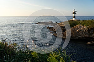 Pancha island lighthouse at sunset in Ribadeo coast, Lugo province, Galicia, Spain photo