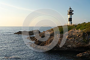 Pancha island lighthouse at sunset in Ribadeo coast, Lugo province, Galicia, Spain photo