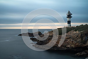 Pancha island lighthouse at sunset in Ribadeo coast, Lugo province, Galicia, Spain photo