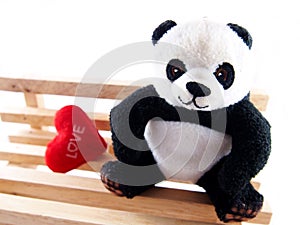 Panda doll on the handmade wooden chair, feeling fall in love concept