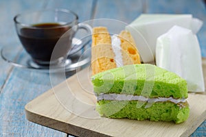 Pandan and coconut chiffon cake on a wooden plate