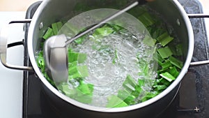 Pandan drink making,stirring pandan leaf in boiled water by stanless ladle