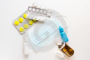 Mask,spray, pills, drops and syringe on white background photo