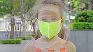 Pandemic, Portrait of Little Girl Wearing Protective Mask on Street in City. Face Child Wearing Mask for Protect Them