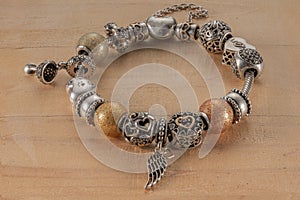 Pandora bracelet with different charms on a wooden table