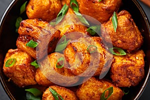 Paneer Manchurian or Paneer 65 in bowl at black slate background. Close up