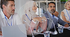 A panel of business delegates talking at a conference