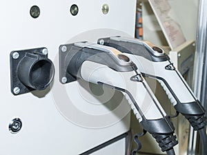 Panel with two guns for charging electric vehicles