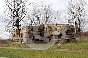 Panels are concrete folded in the street on a green grass near a tree. Preparation for construction works.