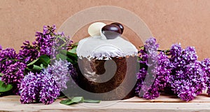 Panettone Easter baked goods are decorated with icing on a background of spring lilac flowers