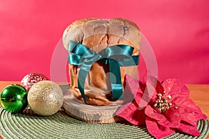 Panettone with green ribbon and red Christmas backgroun