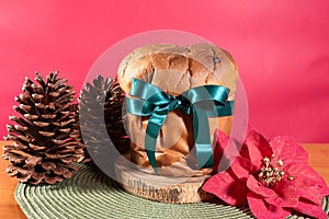 Panettone with green ribbon and red Christmas backgroun