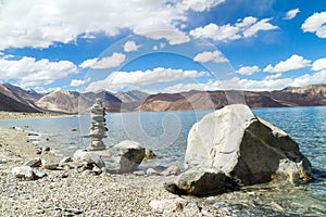 Pangong Tso mountain lake panorama with rocks in forefront