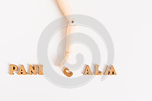 Panic calm concept wooden hand moves letter on light background