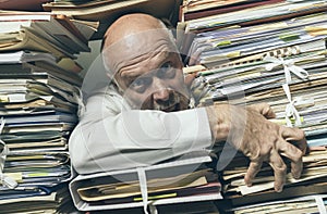 Panicked businessman overloaded with paperwork