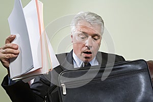 Panicked man looking in briefcase
