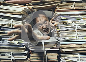 Panicked businessman overloaded with paperwork photo