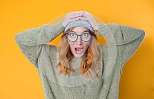 Panicked young woman with open mouth stare to you with popped eyes, isolated on yellow background. Scared female