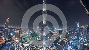 Paniramic skyline view of Dubai downtown with mall, fountains and Burj Khalifa aerial night timelapse