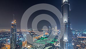 Paniramic skyline view of Dubai downtown with mall, fountains and Burj Khalifa aerial night timelapse