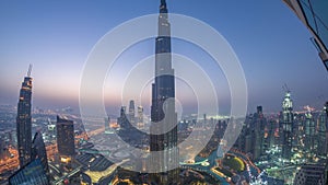 Paniramic skyline view of Dubai downtown with mall, fountains and Burj Khalifa aerial night to day timelapse