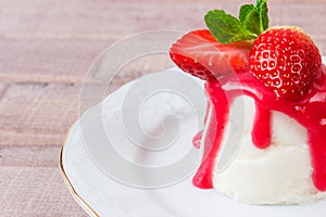 Panna cotta dessert with strawberry sirup and mint leaf